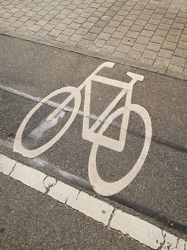 Aufgesprühtes Fahrrad auf einer Straße als (Warn-)Hinweis
