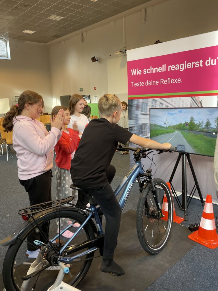 Kind auf einem Fahrrad an der Station "Wie schnell reagierst du?"