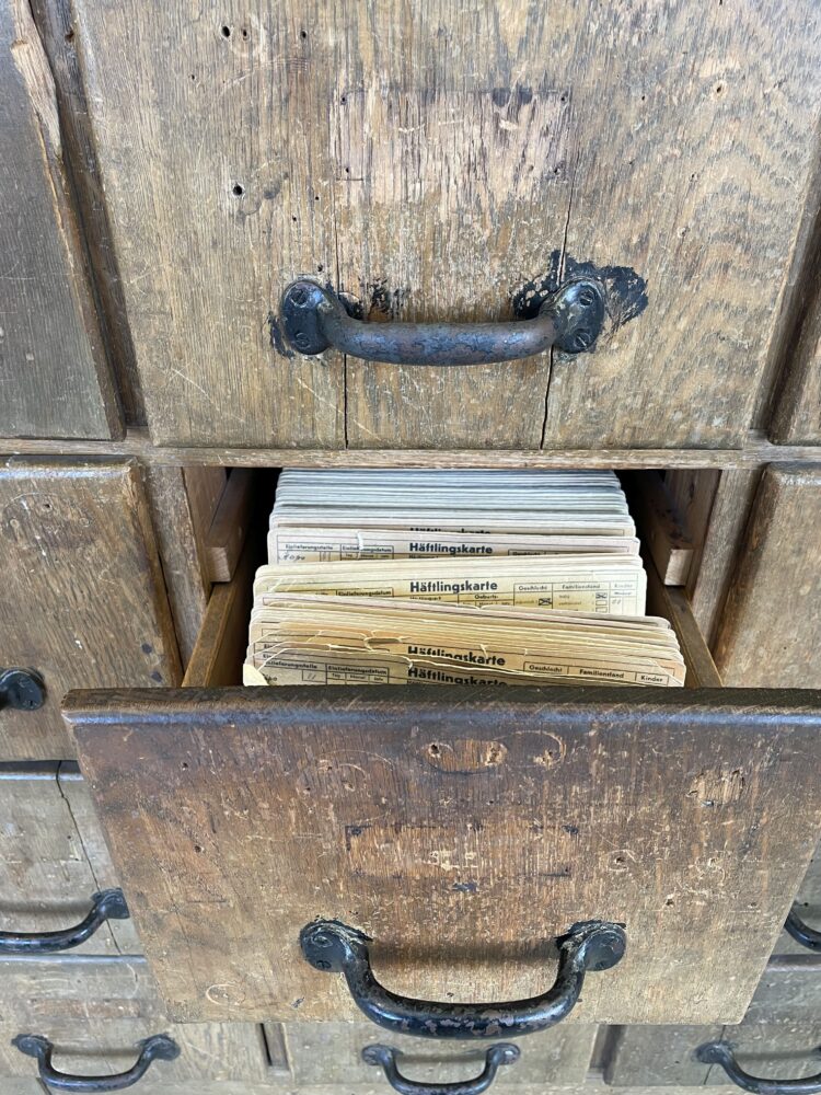 Alter, geöffneter Karteikartenschrank, der Häftlingskarten enthält