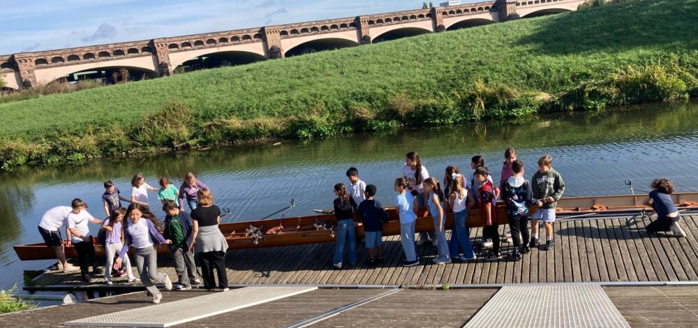 Kinder stehen am Steg und wollen ins Ruderboot einsteigen