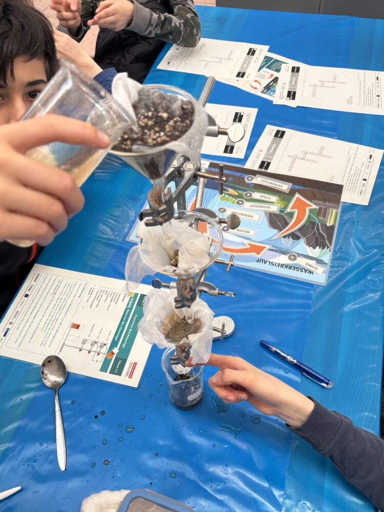Schüler:innen bei einem Wasser-Experiment.