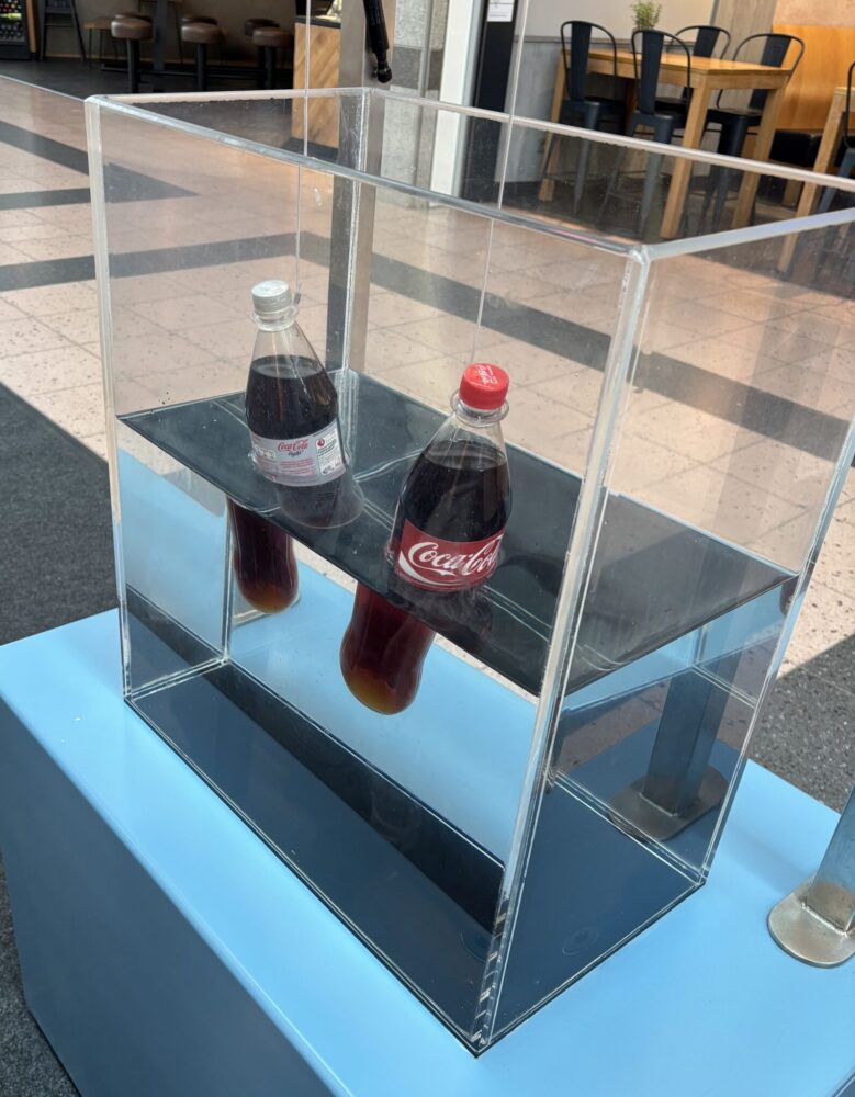 Vergleich zweier Cola-Flaschen im Waser