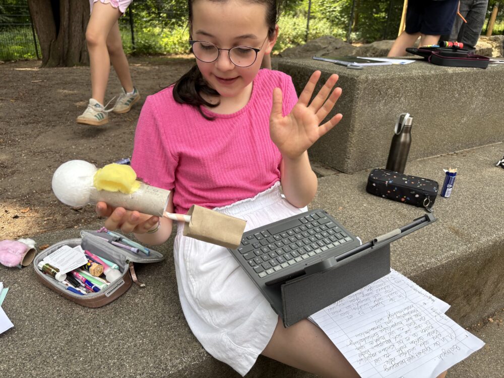 Eine Schülerin mit ihren Notizen, einem iPad und einem Modell für den Wettbewerb bio-logisch