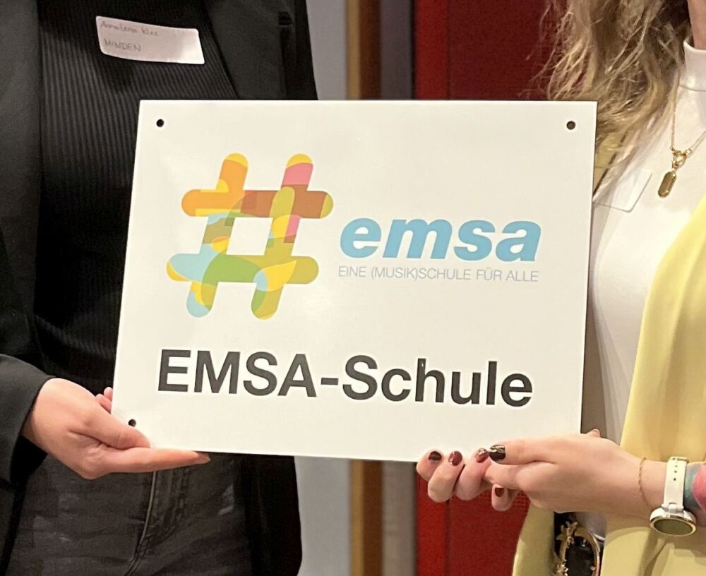 Die EMSA-Plakatte wird in die Kamera gehalten